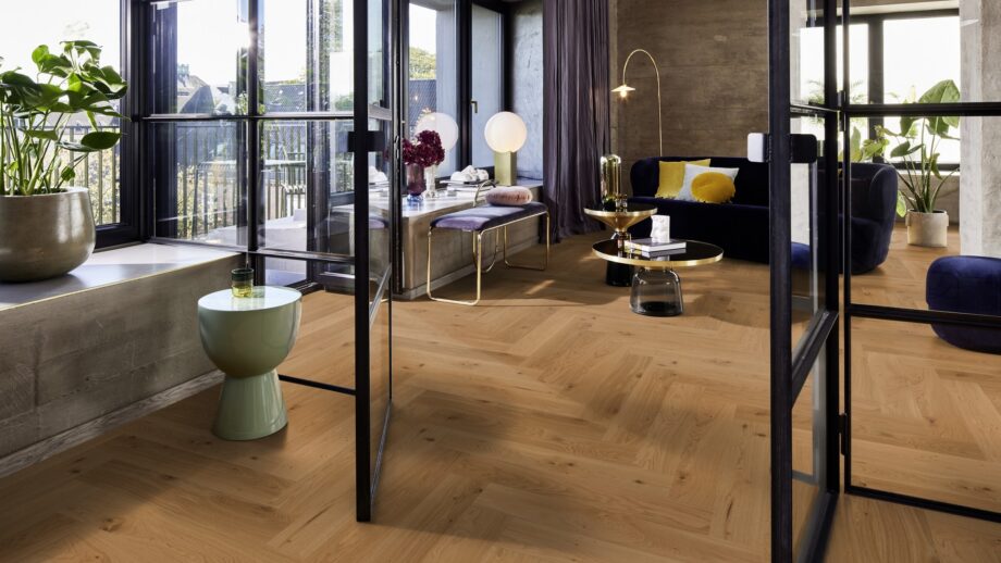 Fischgrätparkett Eiche Mix 140 mm geölt im modernen Wohnzimmer mit Designmöbeln und großen Fenstern.