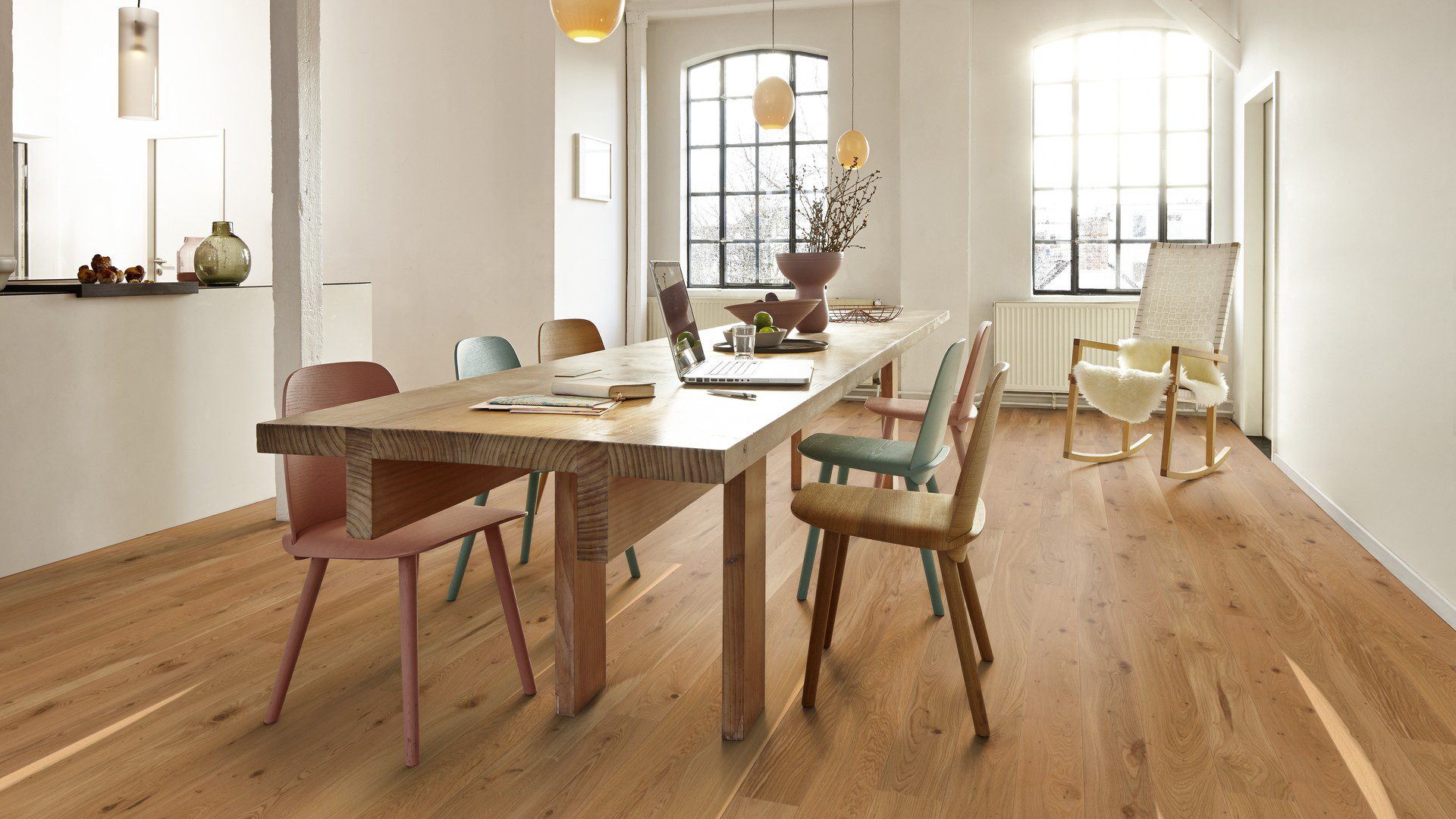 Parkettboden Bauwerk Boen Casapark Eiche 46 Vivo (138 mm), gebürstet und mit Öl-Wachs geölt – verlegt auf dem Küchenboden; großer 6-sitziger Esstisch aus Massivholz mit Stühlen und ein Schaukelstuhl. Rustikale Sortierung mit lebendiger Maserung und Astanteilen.