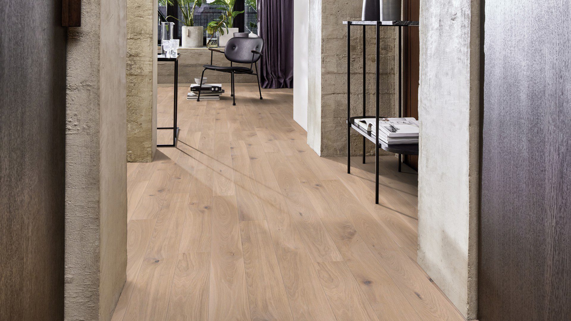 Tammiparketti Bauwerk Boen Casapark tammi 46 Farina, harjattu ja öljyvahattu, asennettuna käytävän ja olohuoneen lattialle – rustiikkiset betonipintaiset seinät. Vaalea Farina-sävy ja rustiikkinen sorteerus tuovat esiin tammen eläväisen kuvioinnin.