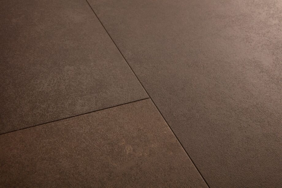 Vinüülparkett Quick-Step Oro Cinnamon rock sooja pruuni tooni ja faasitud looduskivist põrandaplaadi disainiga.