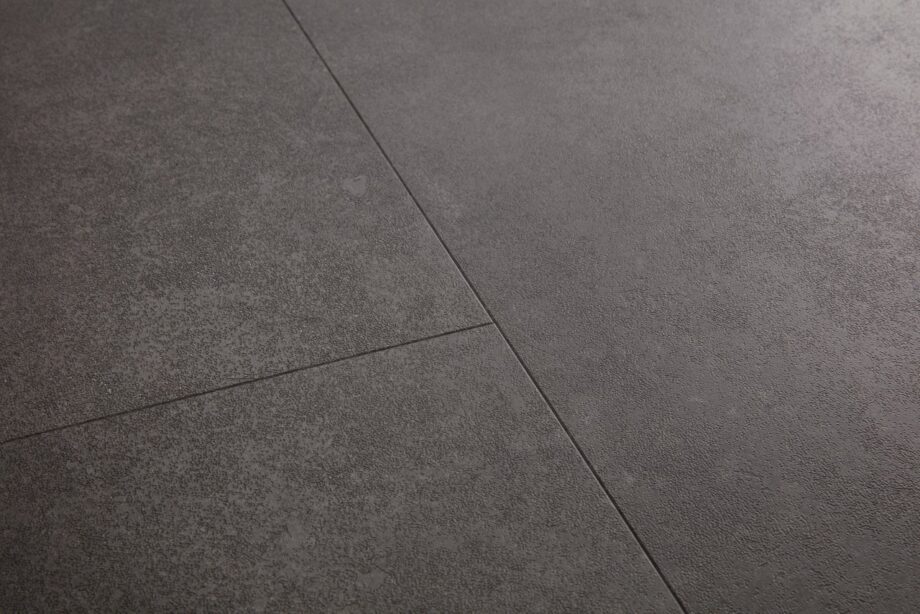 vinyylilaatta-quick-step-oro-volcanic-rock Vinyylilaatta Quick Step Oro Volcanic Rock asennettu lattialle tumma grafiitinharmaa vulkaaninen kivisävy moderni kivikuosi hienovarainen kivipinnan struktuuri ja luonnollinen sävyvaihtelu kestävä ja helppohoitoinen vinyylilattia sisustuksessa