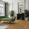 Classical living room with herringbone parquet, marble fireplace, green sofa