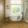 herringbone-laminate-floor-quick-step-impressive-design-cinnamon-oak Herringbone laminate floor Quick-Step Impressive Disain Cinnamon installed to bathroom floor. White separatly standind bathtub