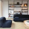 Vinyl Fischgrat Quick Step Ciro Pure Oak Polar, verlegt im Wohnzimmerboden, mit blauem Sofa, Couchtisch und Bücherregal.