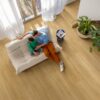 LVT floor Quock-Steü Bloom Brushed Oak Honey installed on the Livingroom floor: Father and son watching a phone on a sofa.