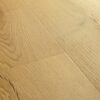 Vinyylilankku Quick Step Bloom Brushed Oak Honey, lämmin hunajainen tammen sävy ja harjattu tammikuviointi.