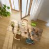 Виниловый паркет Quick Step Bloom Brushed Oak Honey уложен на полу на кухне, обеденный стол со стульями и открытая дверь на террасу.