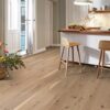 Parkett Bauwerk Boen Casapark tamm 45 Vivo harjatud Avorio hele õli paigaldatud köögi põrandale. Valge fassaadiga köögimööbel ja köögisaar mis kaetud puidust töötasapinnaga.