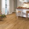 Tammeparkett Bauwerk Casapark Budget Cut tamm 56 harjatud ja õlivahatatud pinnaga paogaldatud köögi põrandale. Põrandal on punutud korv ilusate lilledeka. Köögimööbel ja köögisaar koos toolidega.