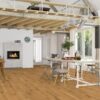 parkettilattia–bauwerk-casapark-tammi-56-harjattu-oljyvahattu Tammiparketti Bauwerk Casapark Tammi 56 harjattu öljyvahattu asennettuna olohuoneen lattialle – harmaa sohva, keltainen nojatuoli ja pienet pyöreät sohvapöydät, joiden alla on harmaa tilkkumatto; luonnollinen tammen sävy, harjattu pinta ja elävä puukuvio.